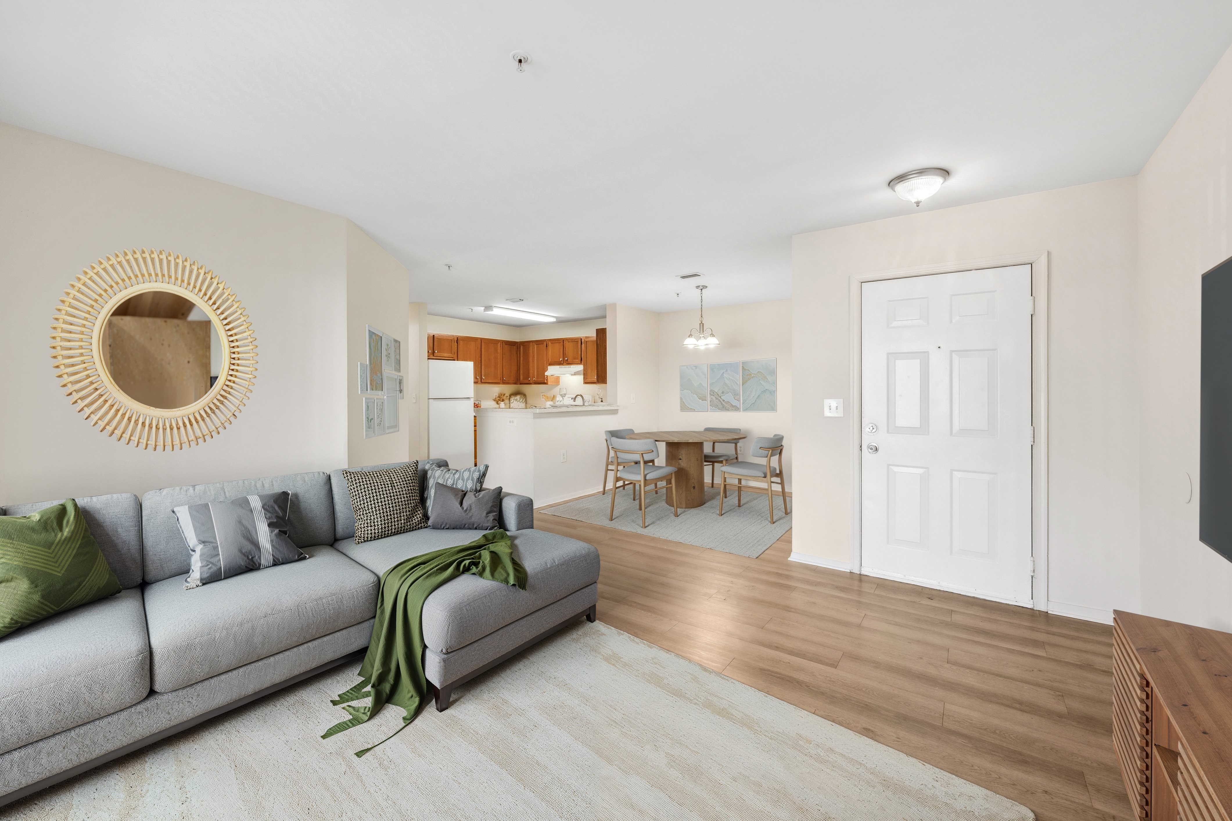 A living room with a grey couch and a wooden floor.